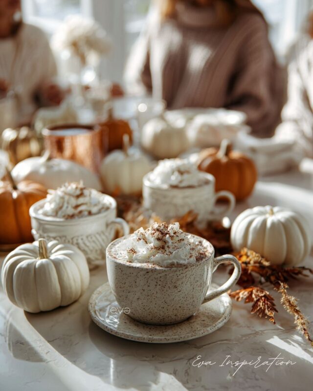 Boisson chaude chocolat chaud à la chantilly sur table automne décorée de citrouilles blanches.