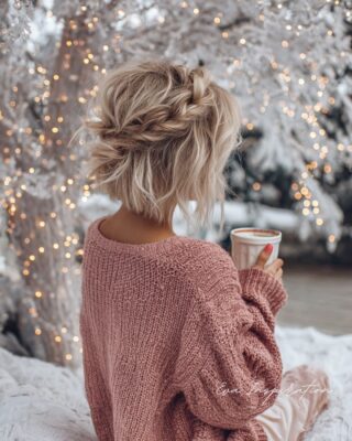 Carré court blond méché avec tresse floue façon couronne et lumière de Noël en fond