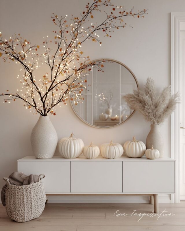 Idée de décoration d’entrée intérieure automne avec citrouilles blanches et accents lumineux pour une ambiance épurée.