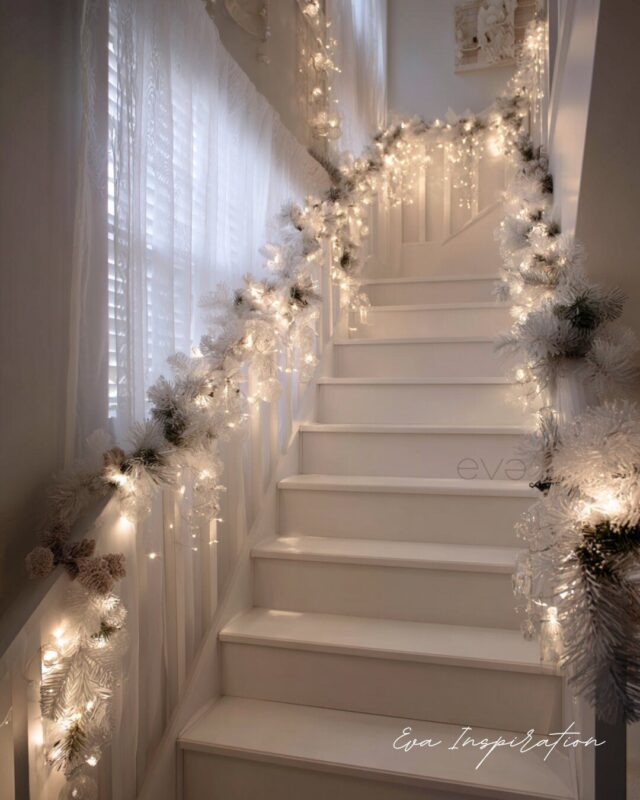 Escalier de Noël blanc décoré de guirlandes lumineuses et branches givrées