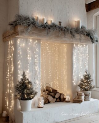 Cheminée blanche décorée de guirlandes lumineuses, mini sapins et bûches pour Noël