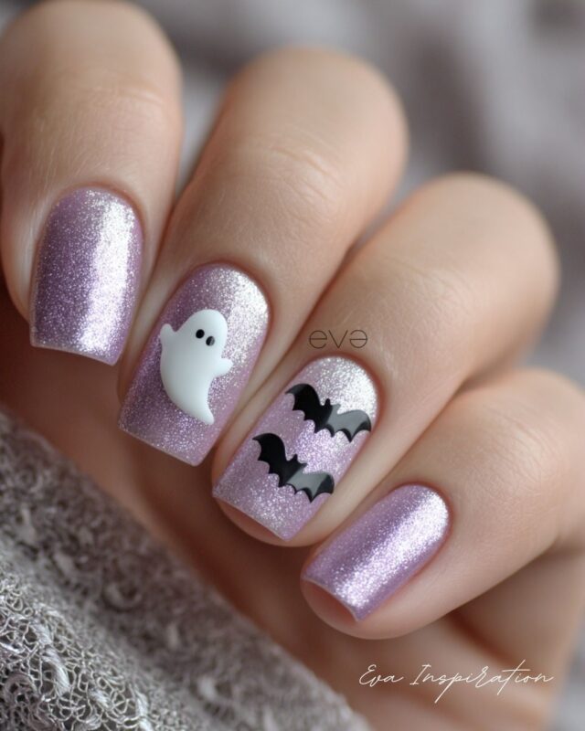 Ongles Halloween violet pailleté avec fantôme et chauves-souris – idée nail art glamour.