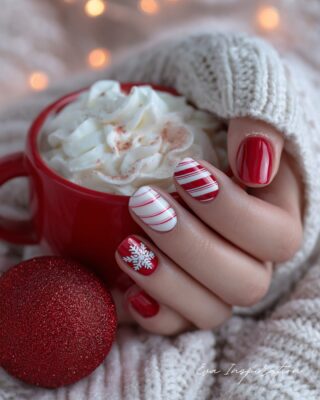 Ongles rouge et blanc avec flocon et rayures style sucre d’orge pour les fêtes de Noël.